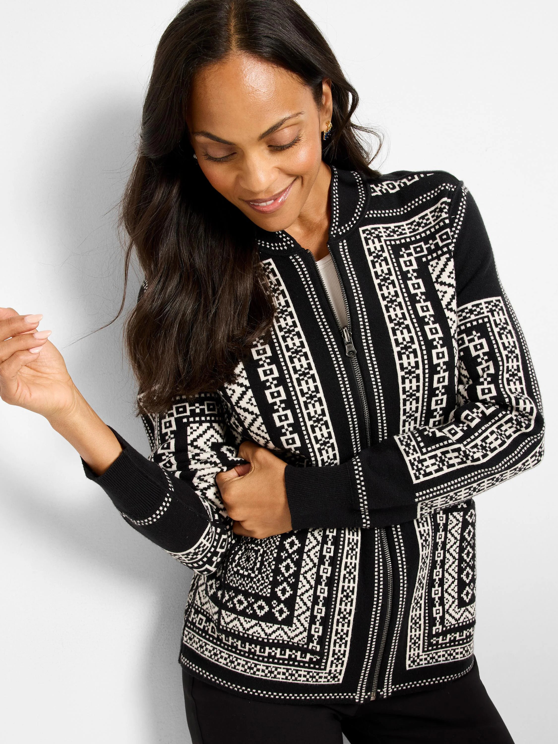 Black and white zip-up jacket with Nordic geometric patterns. Features ribbed cuffs and hem.