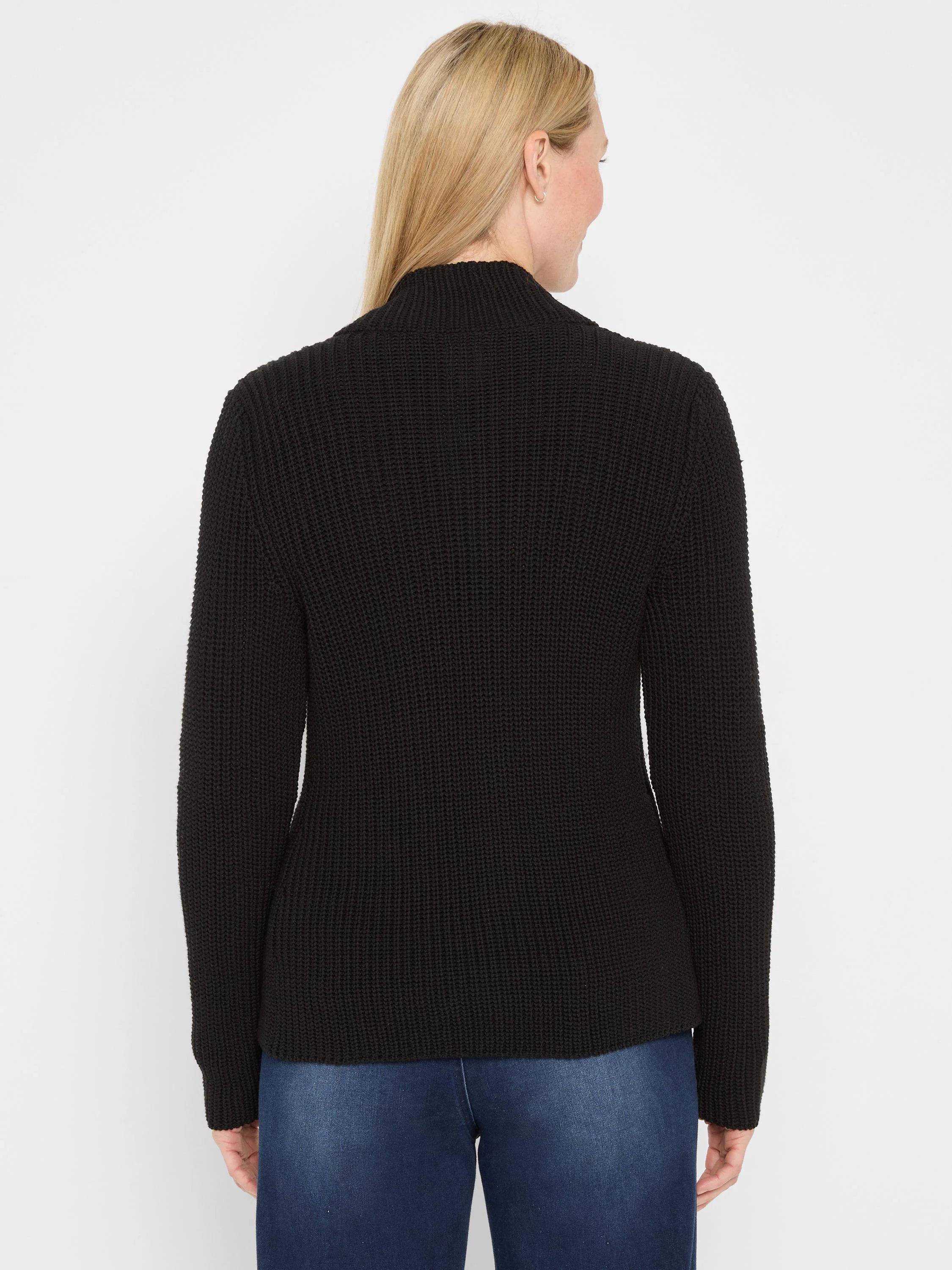 Black shaker knit jacket with ribbed texture and mock neck, worn by a woman from behind.