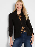 Black shaker knit jacket with a collar, two brown buttons, and long sleeves with ruched cuffs.