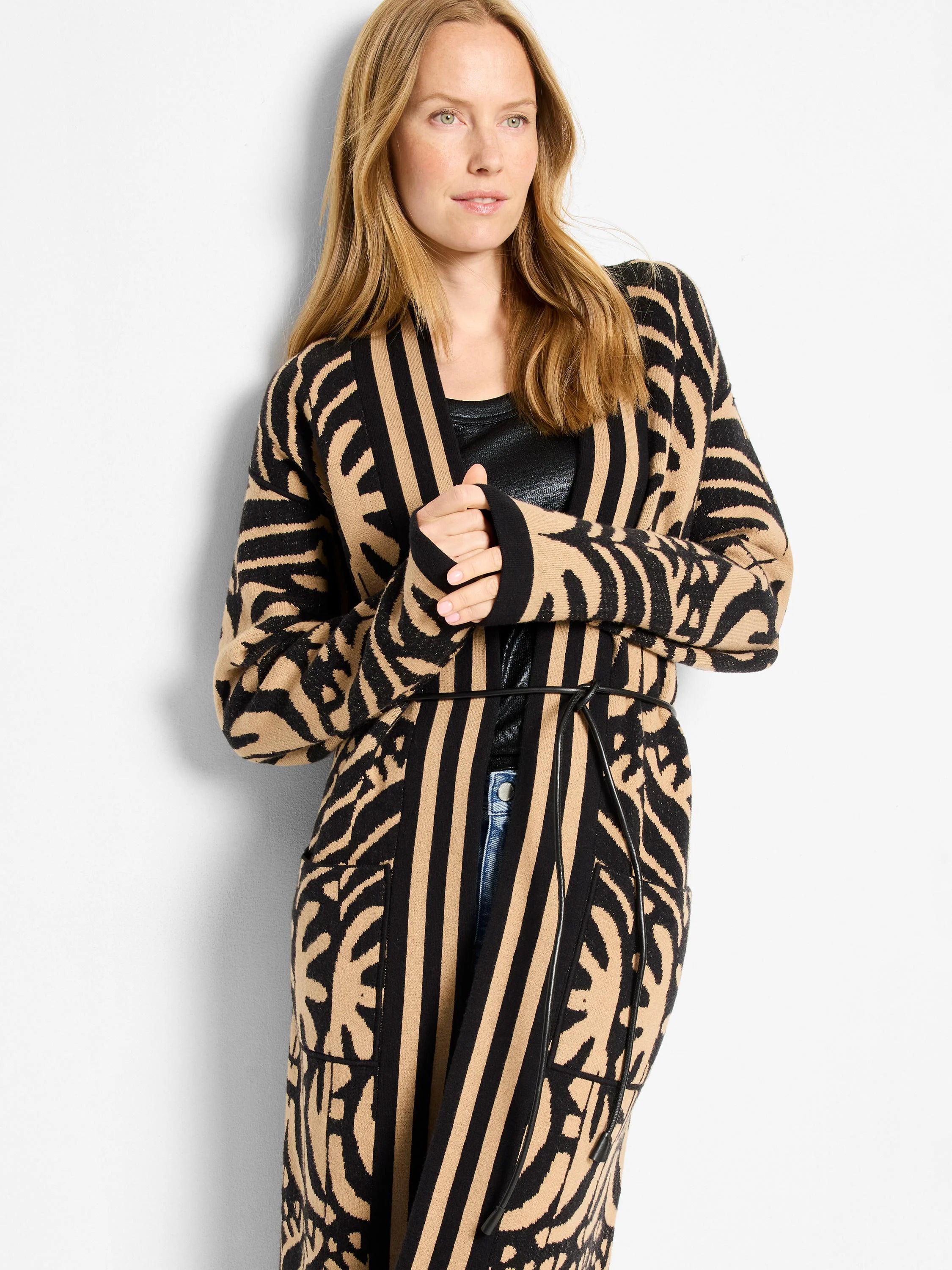 Black and tan knit long jacket with bold abstract zebra print and vertical stripes, cinched by a black tie belt.