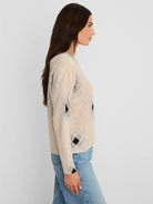 Beige shaker stitch sweater with black and light grey diamond print.