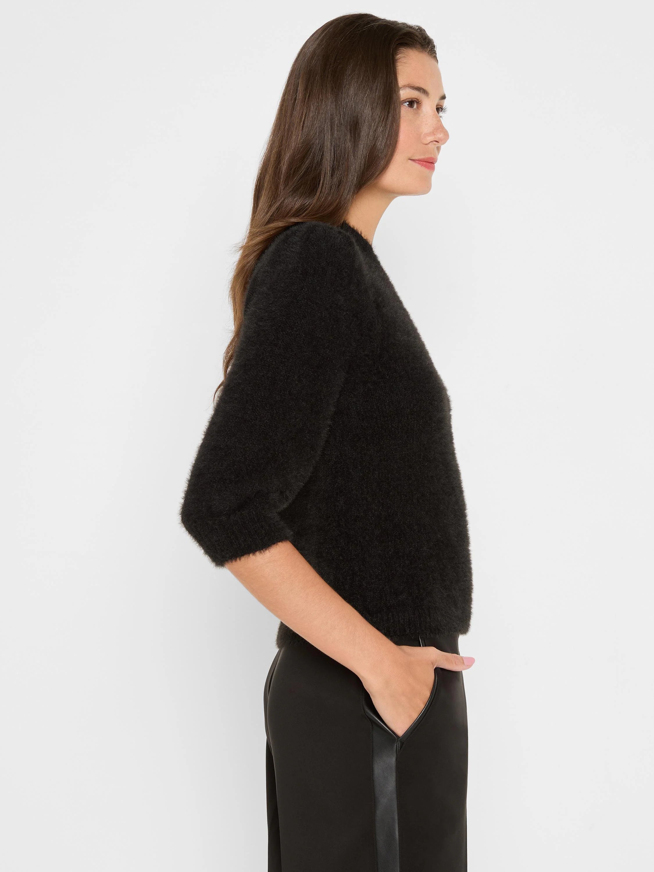 Black fuzzy knit sweater with 3/4 sleeves and ribbed cuffs, modeled on a woman.