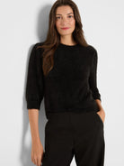 Black fuzzy cropped sweater with 3/4 sleeves and a crew neck.