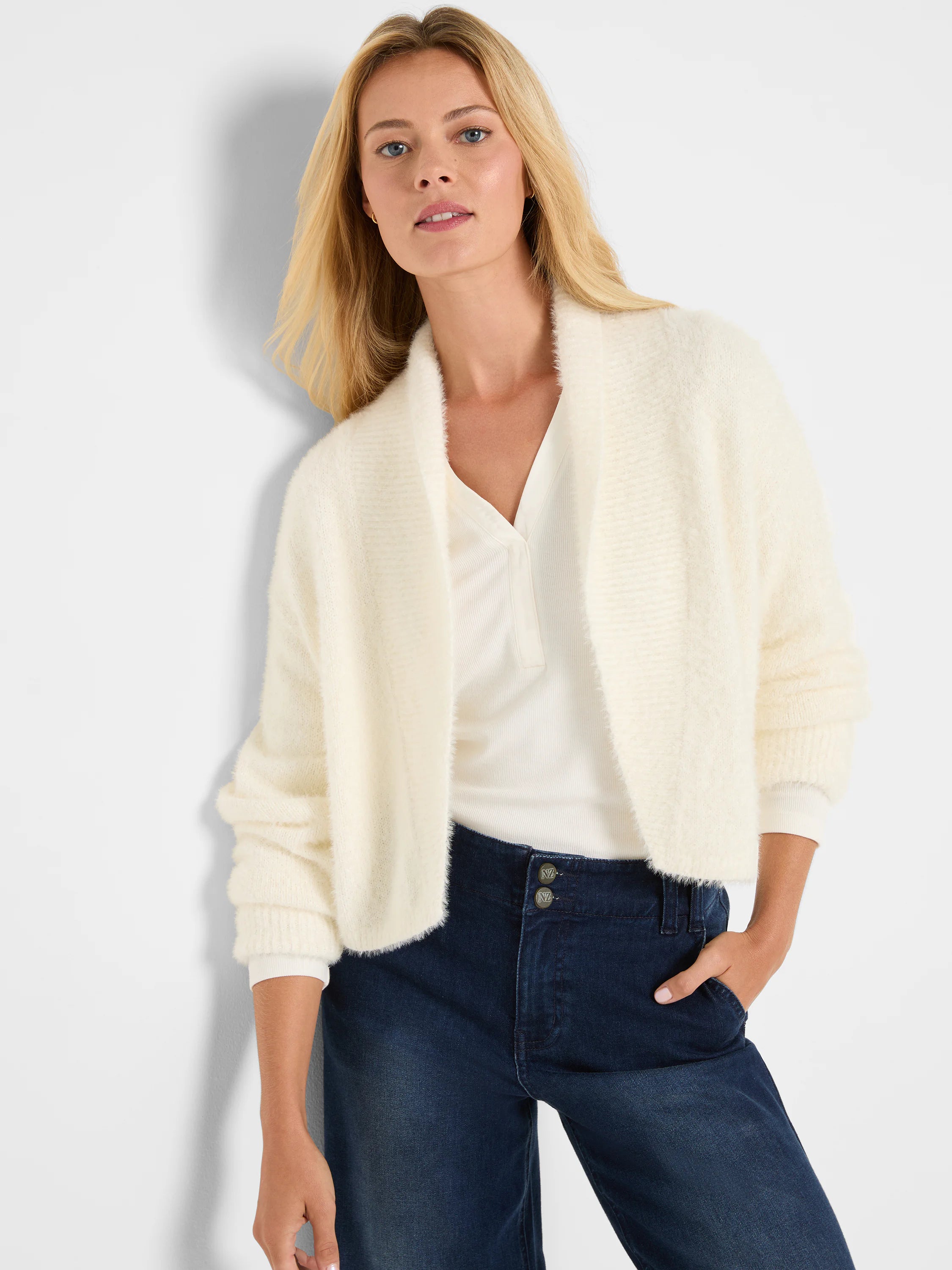 Cream fuzzy knit shrug cardigan with wide shawl collar and ribbed cuffs.