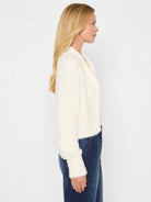 Cream fuzzy open cardigan with a shawl collar and ribbed cuffs.