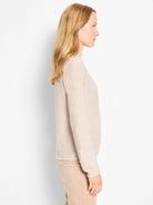Light beige sweater with pixel knit texture, mock neck, and long sleeves.