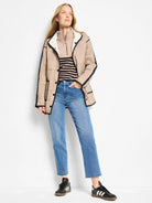 Light beige ribbed sweater with a zip mock neck and saddle shoulders.