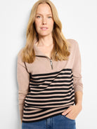 Tan zip-neck sweater. Upper solid tan, lower half black and tan horizontal stripes. Silver zipper.