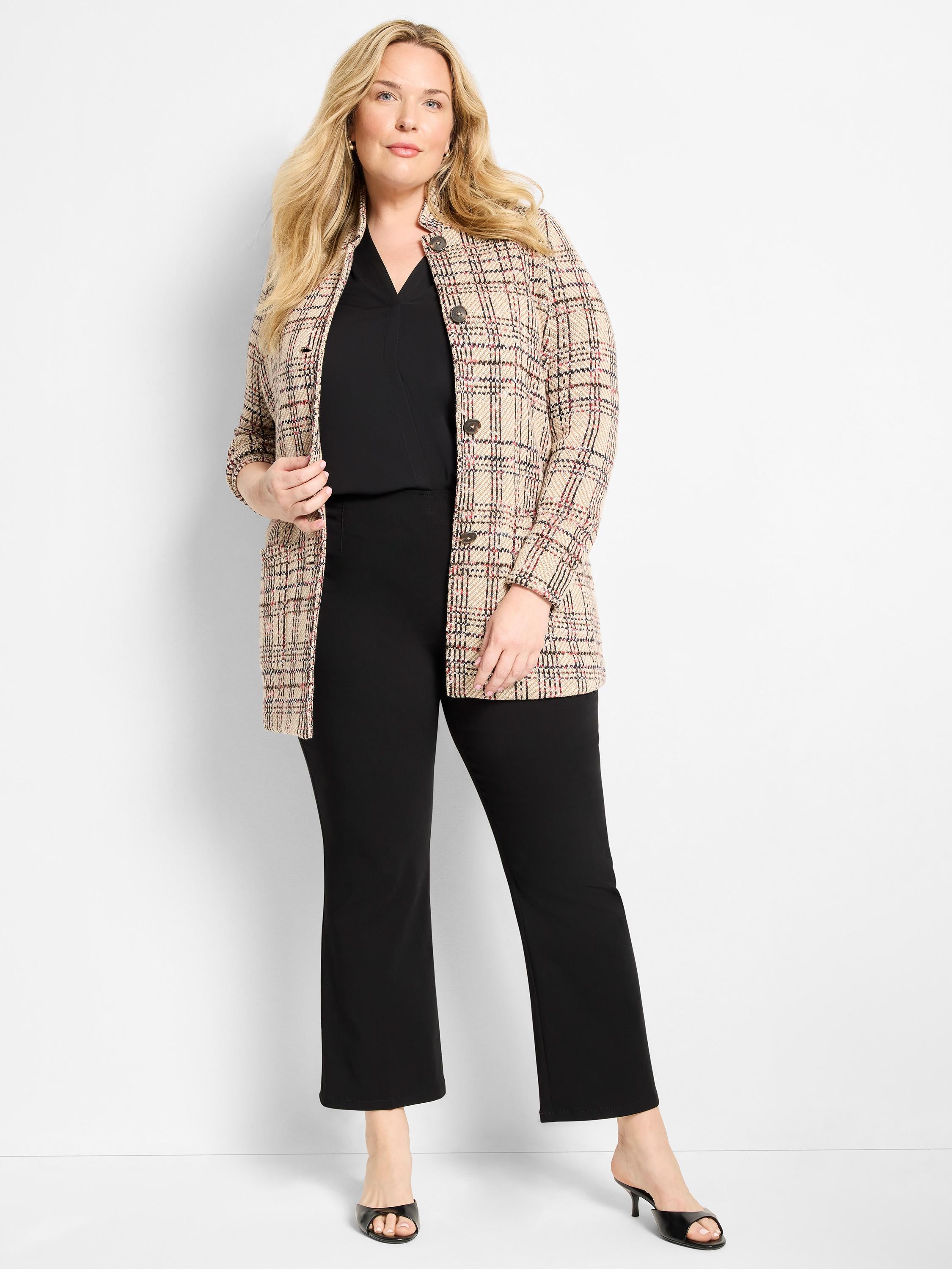 Long, relaxed beige plaid tweed coat featuring a stand collar and large buttons worn over black separates.