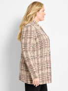 A longline beige knit plaid blazer with a relaxed fit and black and red accents is worn.
