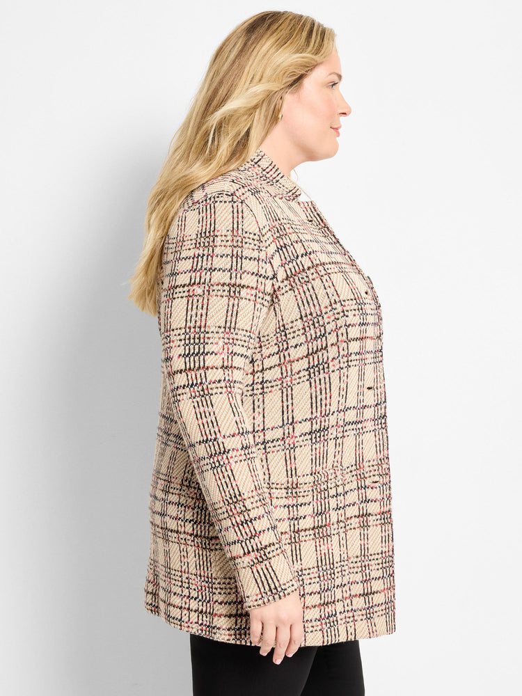 A longline beige knit plaid blazer with a relaxed fit and black and red accents is worn.