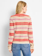 Red, light pink, dark pink, and tan geometric knit cardigan with horizontal stripes and diamond patterns.