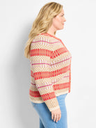 Cream, red-orange, and pink geometric knit cardigan featuring horizontal stripes and diamond patterns.