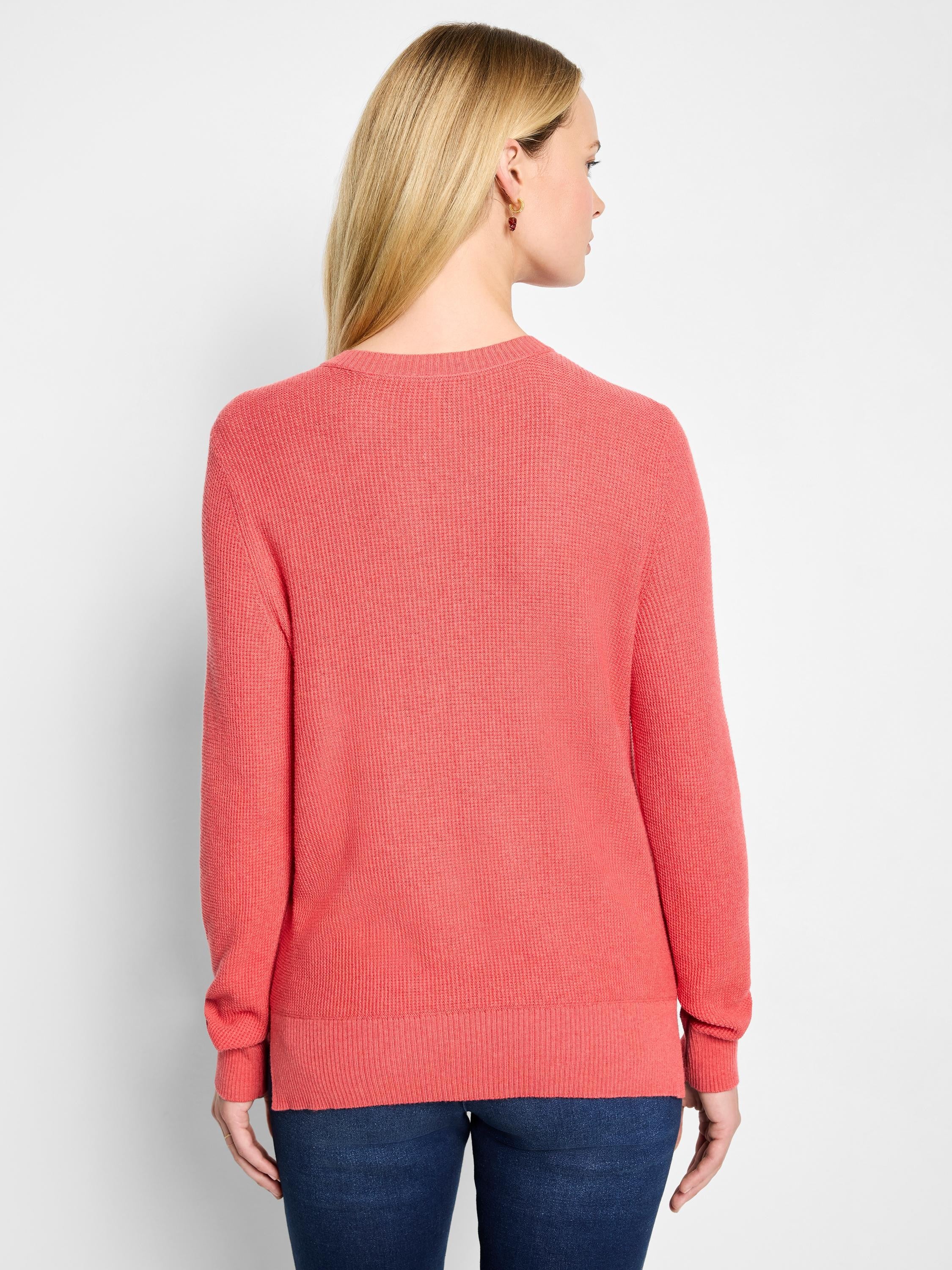 Back view of a coral waffle knit sweater with a crew neck, ribbed cuffs, and hem.