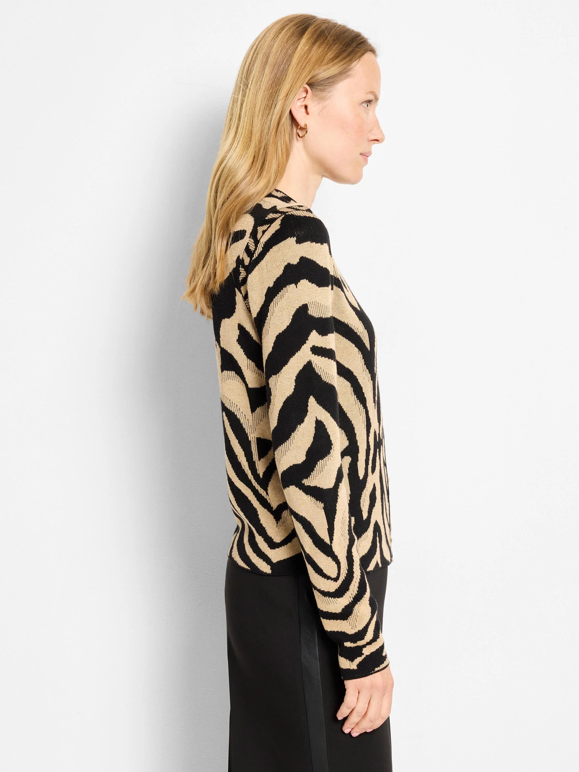 Black and beige zebra print cardigan on a model, shown from the side.