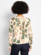 Beige knit sweater with shimmery green, brown, and tan camouflage pattern. Round neck, long sleeves.