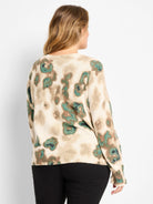 Cream sweater with tan and shimmering teal abstract camo print.
