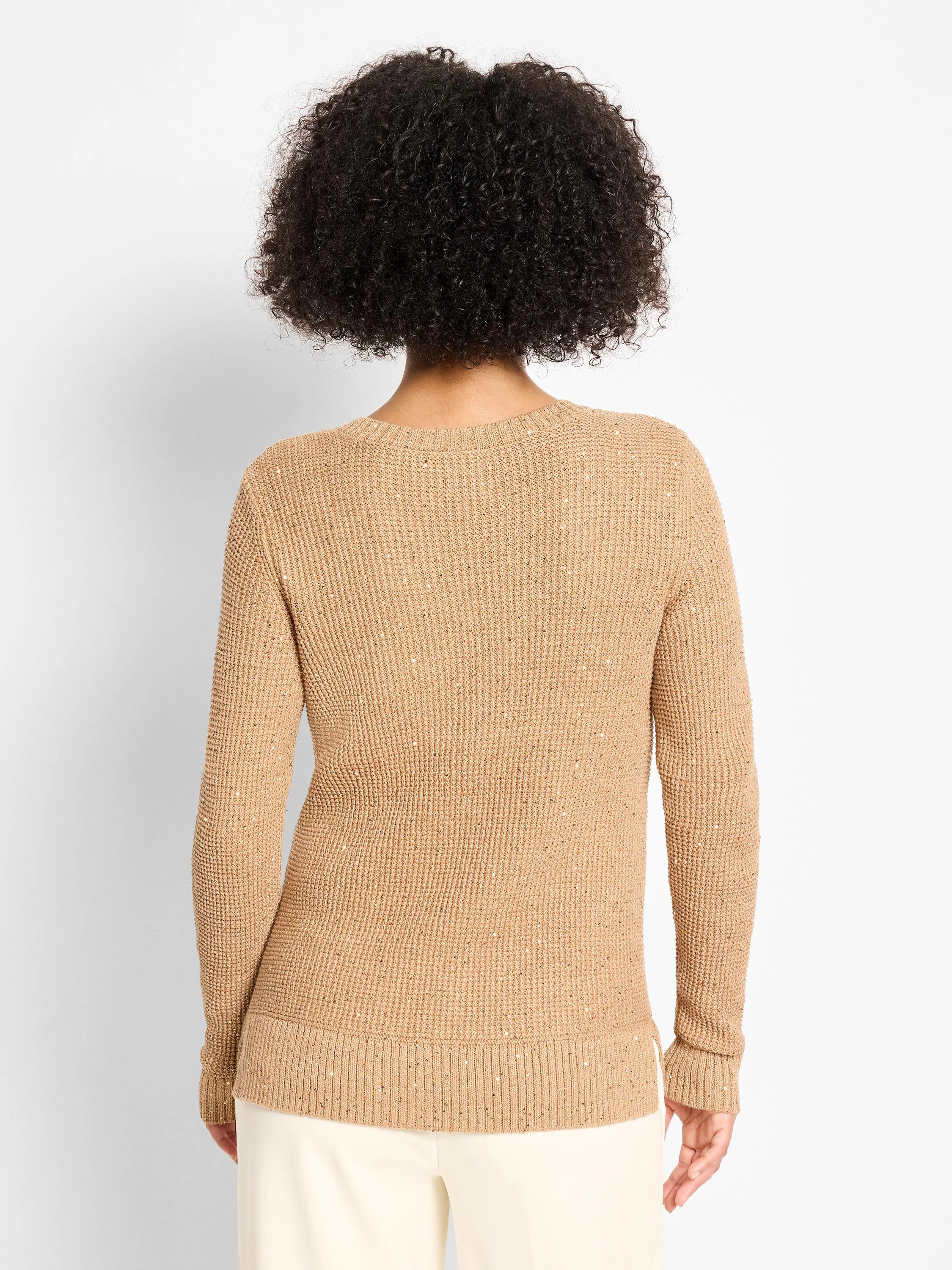 Back of a tan waffle knit sweater. The textured fabric has scattered tiny reflective flecks for shimmer.