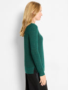Emerald green shimmer waffle knit sweater with side slits, shown in profile.