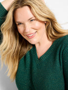 Emerald green V-neck sweater with a textured, waffle-like knit. Features gold shimmer and tiny sequins.