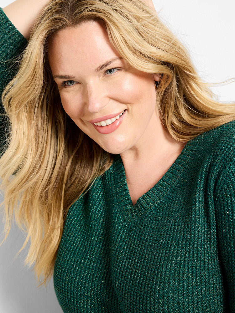 Emerald green V-neck sweater with a textured, waffle-like knit. Features gold shimmer and tiny sequins.
