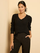 Black V-neck waffle knit sweater with shimmering sequins, relaxed fit.