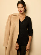 Black V-neck waffle knit sweater with scattered shimmer details.