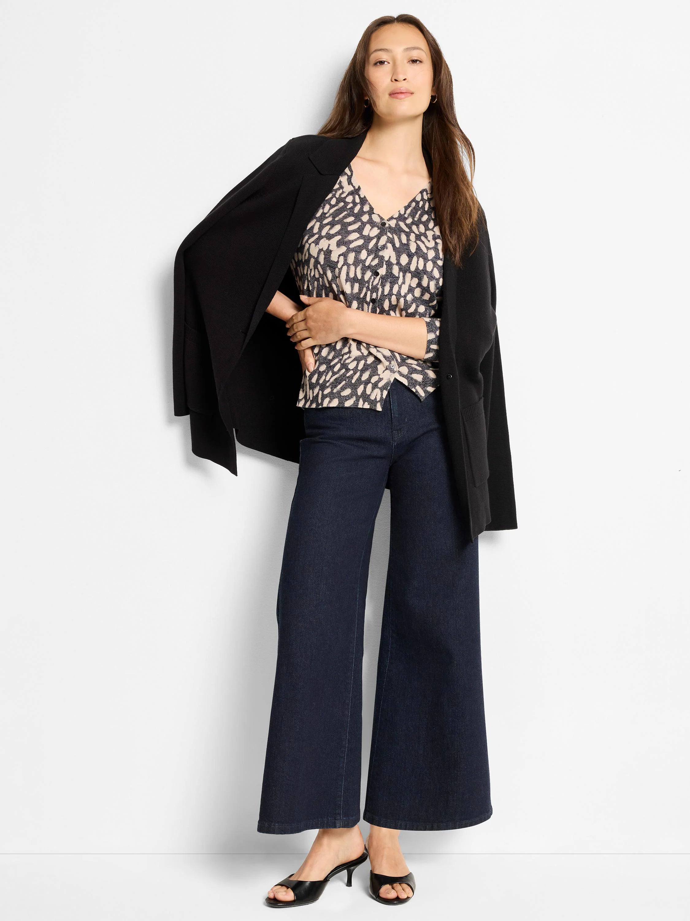 Cream V-neck sweater with dark irregular "wild dot" pattern and small front buttons.