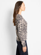 Dark gray & beige abstract dot pullover sweater with a V-neck, shown on a model in profile.
