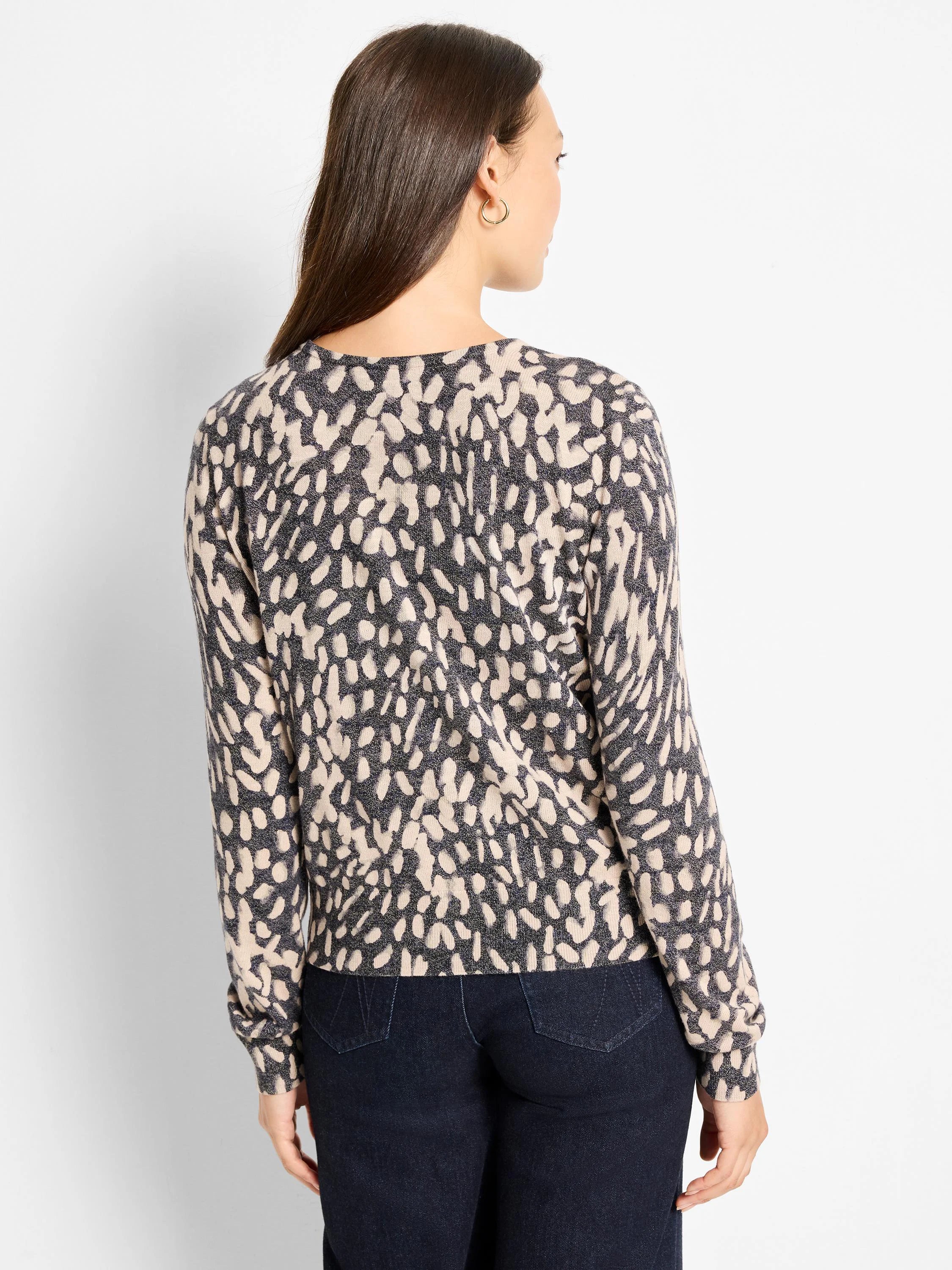 Black and cream wild dot pattern pullover sweater, back view.