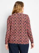 Dark navy sweater with a geometric ikat pattern in red, orange, brown, and blue diamond shapes. Back view.