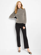 Cream and black pixel knit funnel neck sweater with ribbed black cuffs and hem.