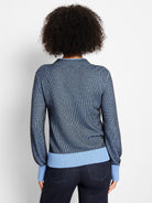 Back: Funnel neck sweater, black base with light blue pixel knit pattern, ribbed light blue cuffs and hem.