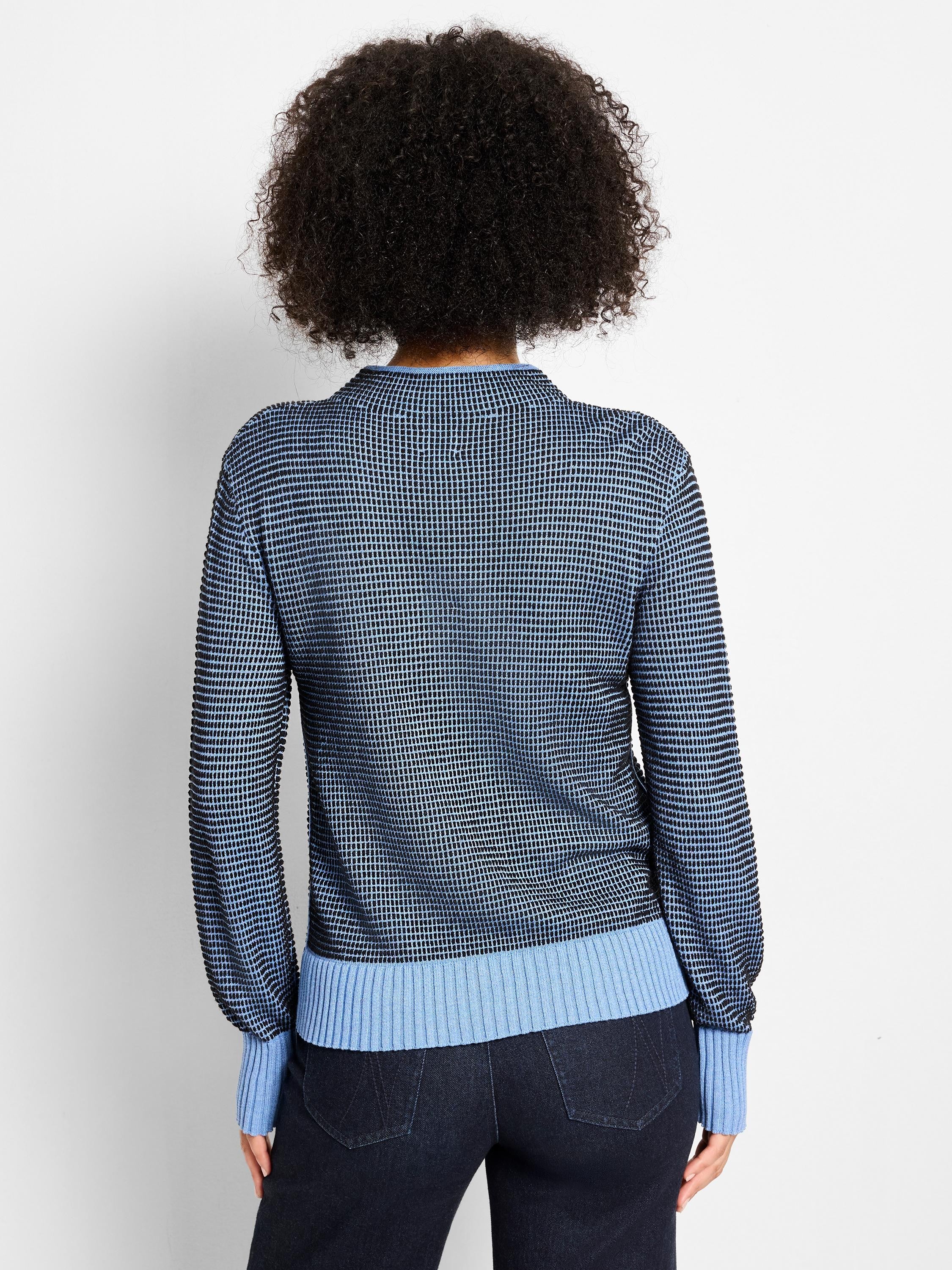 Back: Funnel neck sweater, black base with light blue pixel knit pattern, ribbed light blue cuffs and hem.