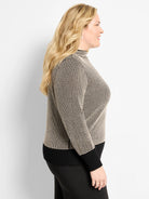 Funnel neck pixel knit sweater in black & beige. Textured pattern, with solid black ribbed cuffs & hem.