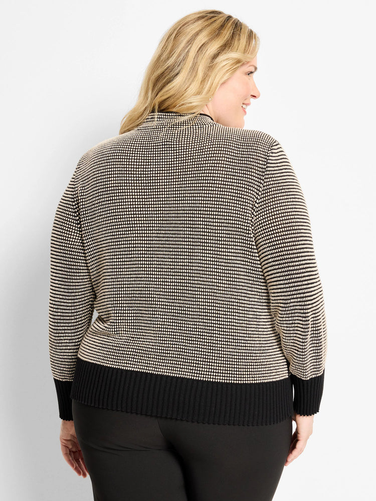 Black and cream pixel knit funnel neck sweater, shown from behind. Features ribbed black cuffs and hem.