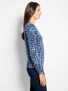 Long-sleeve sweater in shades of blue & white, featuring an abstract, irregular knit-stitch pattern.