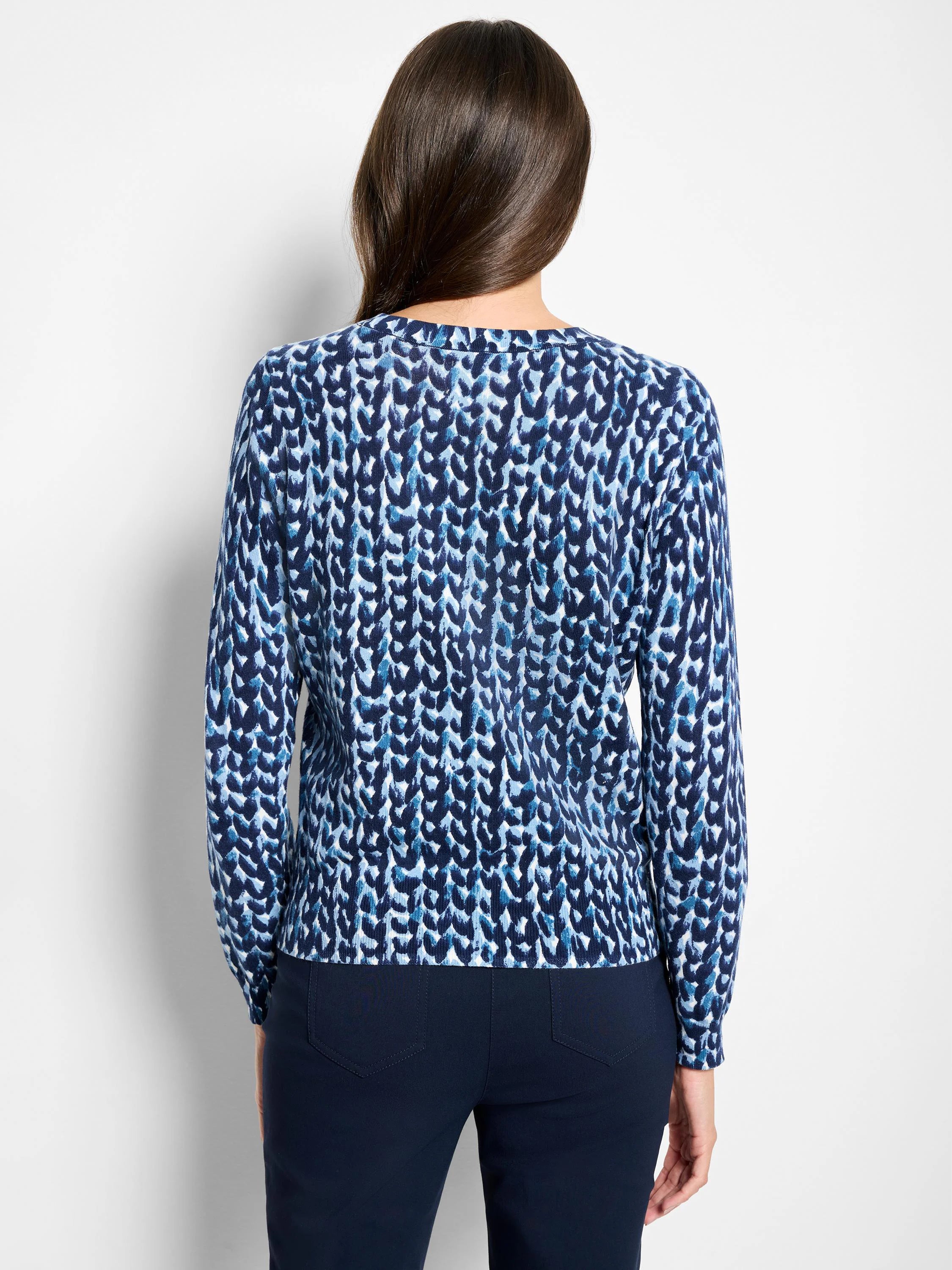 Back view of a pure cotton sweater with a knit stitch pattern in dark blue, light blue, and white.
