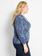 Knit sweater with abstract blue & white pattern, mimicking knit stitches. Shades of navy, medium blue, & light blue.