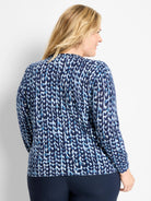 Long-sleeved sweater with a mottled knit stitch pattern in dark blue, light blue, and white.