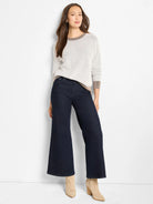 Light cream textured cotton sweater with diagonal knit pattern and brown ribbed trim at collar, cuffs, and hem.