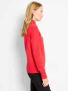 Red mock neck sweater with long sleeves, ribbed cuffs and hem, and a soft knit texture.