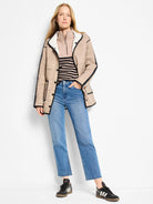 Beige quilted jacket with chevron pattern and black trim. White collar lining shows reversibility.