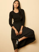 Black ribbed knit top dress with a pleated midi skirt.