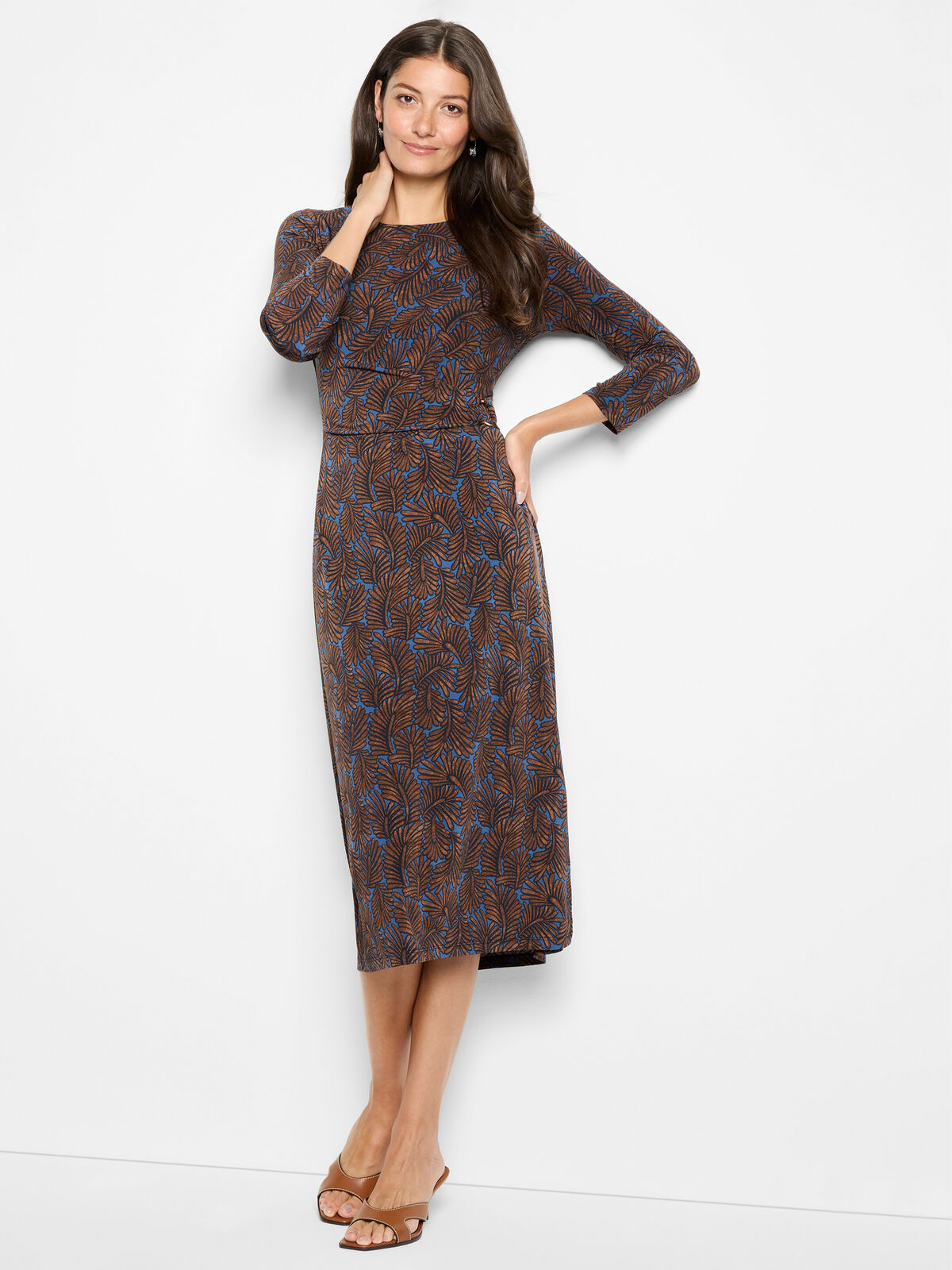Woman wearing a patterned dress on a white background