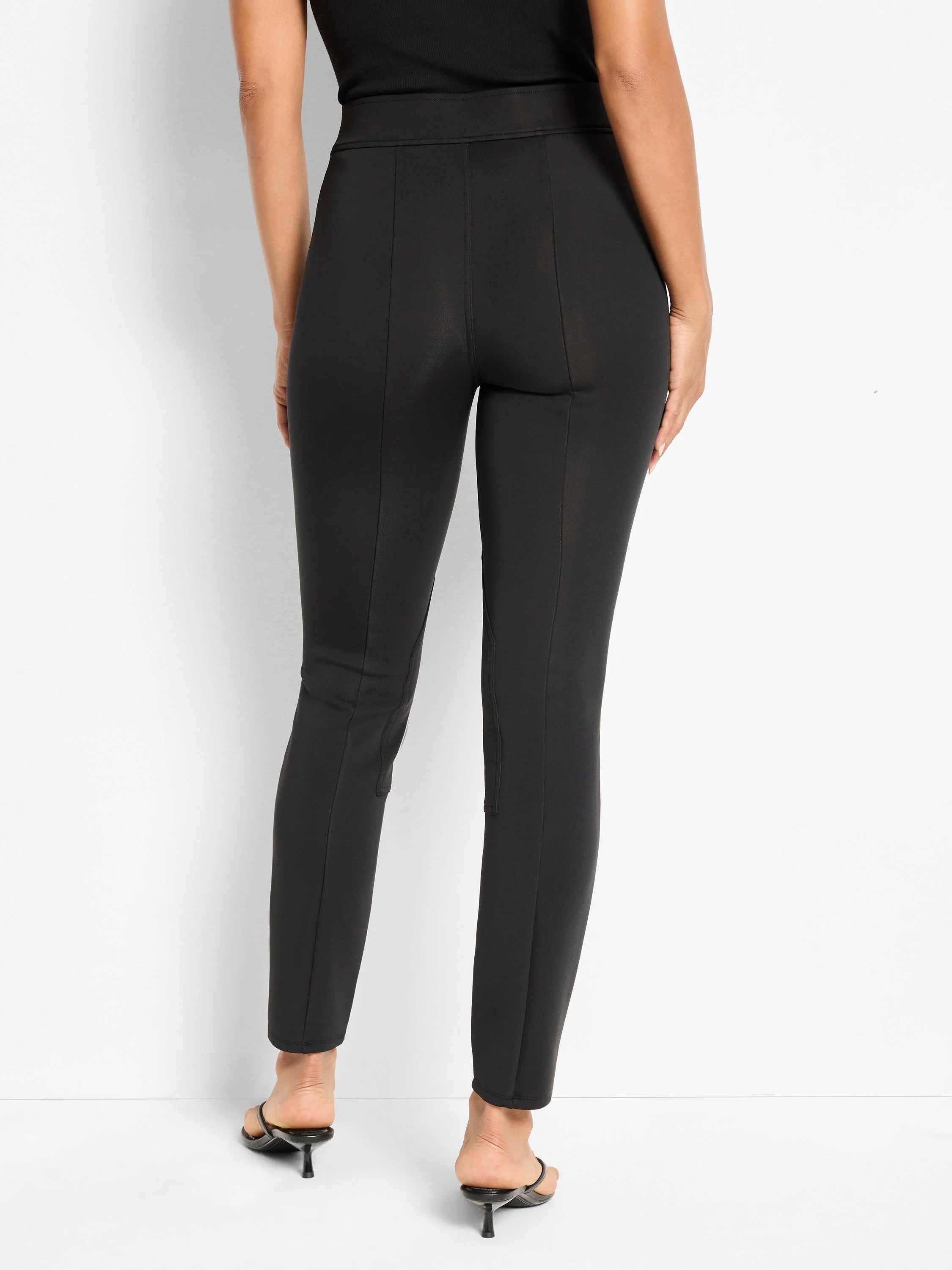 Black interlock scuba riding pants, slim-fit and high-waisted, with vertical seams on the back of each leg.