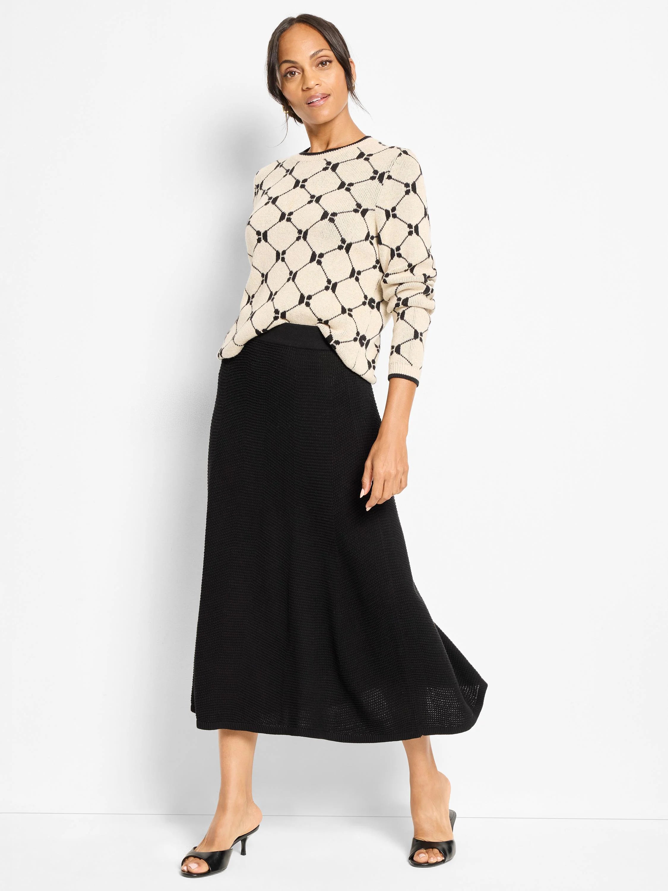 Black midi-length knit skirt with a pixel knit texture and a flared silhouette.