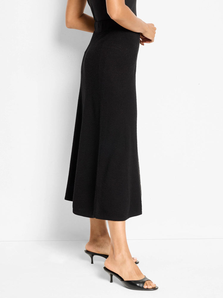 Black knit midi skirt with a pixelated chevron texture, gently flaring.