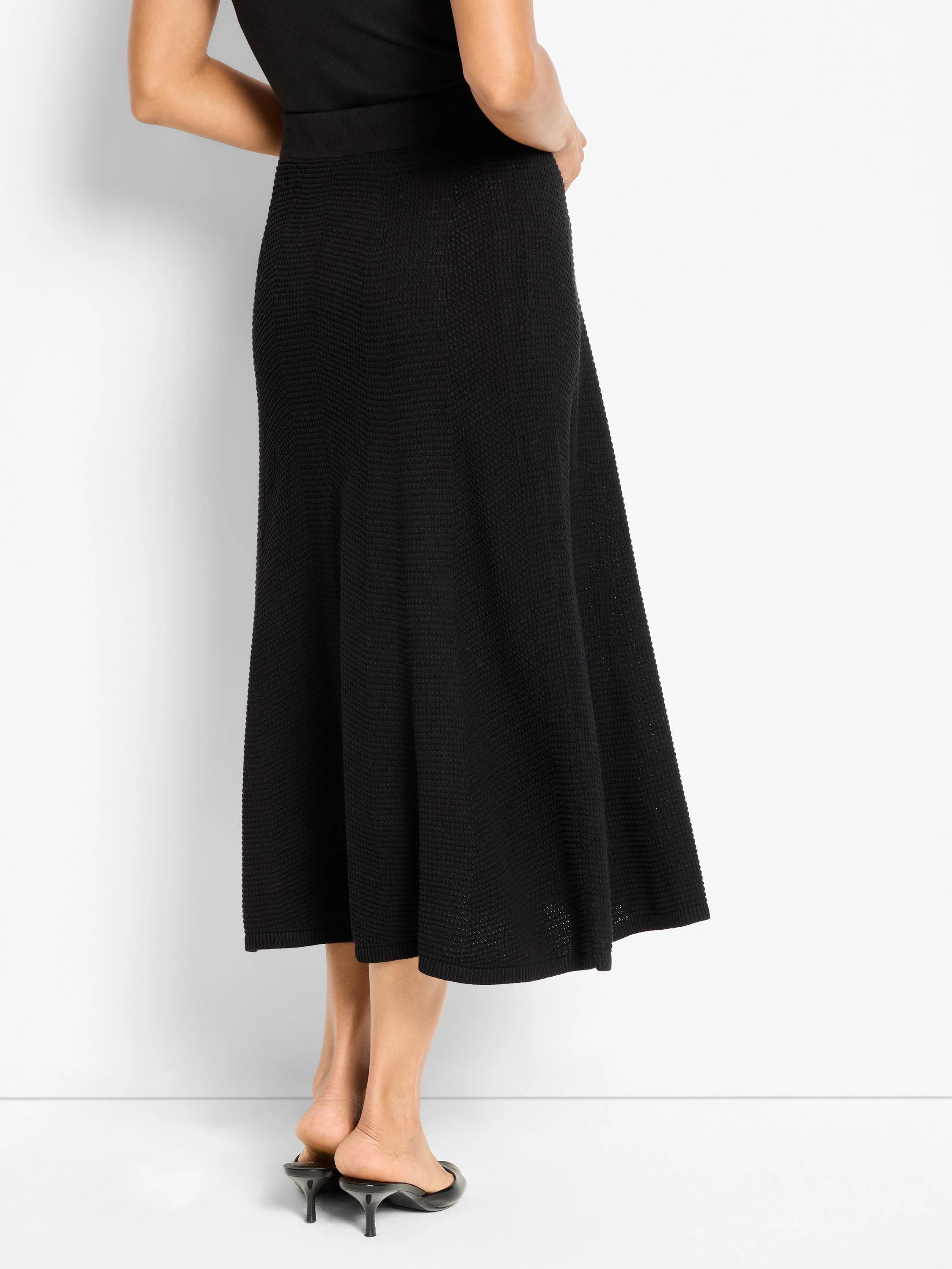 Black midi skirt with a raised, pixelated knit pattern, featuring a gentle flare.