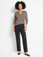 Black straight ankle jeans on a model, featuring a flat waistband and straight leg.